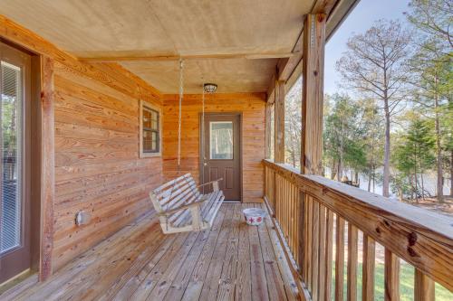 a porch of a wooden cabin with a rocking chair at Waterfront Milton Home with Boat Dock! in Milton