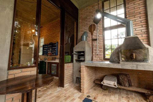 a kitchen with a stone oven in a brick wall at Design Home by The Lodges in Campos do Jordão