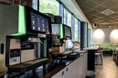 a bar with two monitors on a counter in a restaurant at Novotel Suites München Parkstadt Schwabing in Munich