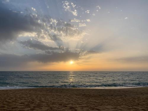 a sunset on the beach with the sun setting at Villa Mia in Seneghe