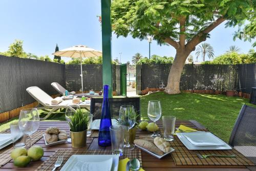 a table with plates of food and wine glasses at Cozy Bungalow Playa Flor Maspalomas by VillaGranCanaria in Maspalomas