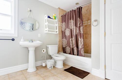 a bathroom with a tub and a toilet and a sink at Private 4 bedrooms 2 bathrooms Free Parking in Lower Sackville