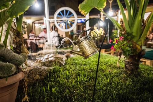 a garden with a watering can in the grass at B&B Casa Cosmano in Brancaleone Marina