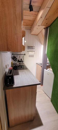 une cuisine avec des armoires en bois et un comptoir dans l'établissement le relais de l'abelan, à Blesle