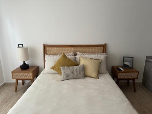 a bedroom with a large white bed with pillows at Departamento en Puerto Aventuras in Puerto Aventuras