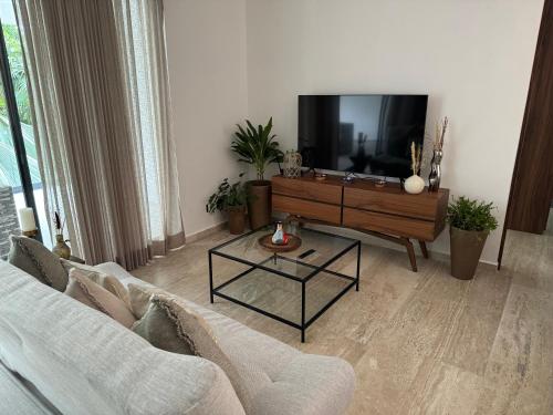 a living room with a couch and a flat screen tv at Departamento en Puerto Aventuras in Puerto Aventuras