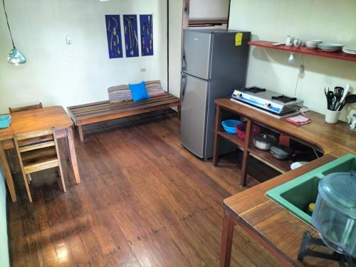 a kitchen with a refrigerator and wooden floors at Cabinas Coconut Grove in Puerto Viejo