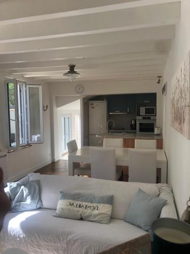 un salon avec un canapé blanc et une cuisine dans l'établissement Maison Royan Pontaillac 300m de la plage, à Royan