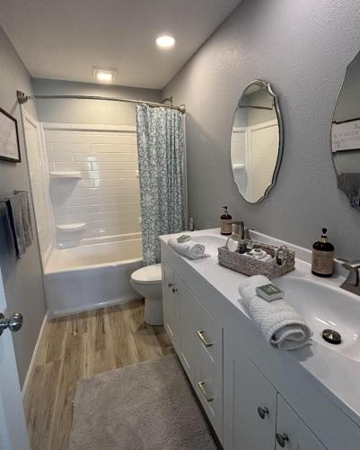 a bathroom with a sink and a toilet and a mirror at Lake Ozark's Lakefront Oasis with Fireplace, Game Room, Theater & More! in Osage Beach