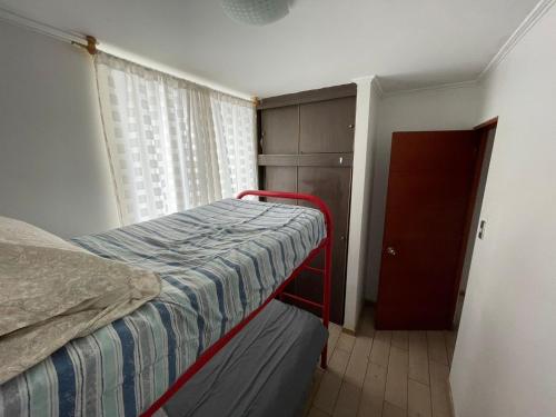 a small bedroom with a bed and a window at Edificio INMOBILIA - Av Argetina 2 dormitorios in Antofagasta
