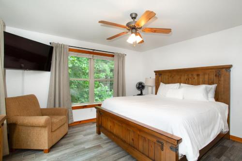 a bedroom with a bed and a ceiling fan and a chair at Firefly Ridge MTN View Hot Tub Theater GAMES in Townsend