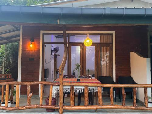 a house with a table and chairs on a porch at Cozy Homestay Waterfall Road Ella in Ella
