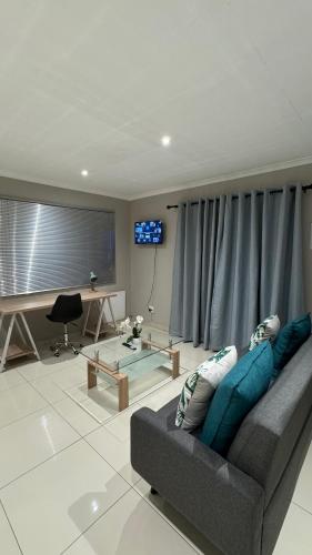 a living room with a couch and a table at The Manor in Midrand