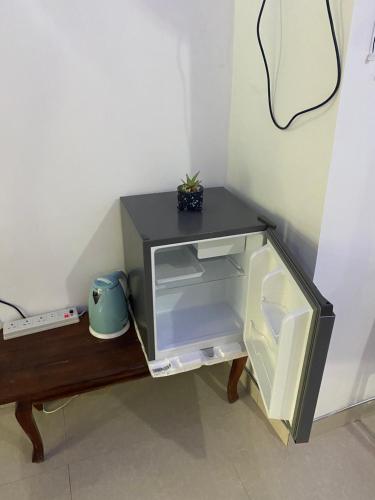 a microwave oven sitting on a table with its door open at Cozy Homestay Waterfall Road Ella in Ella