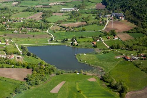 an aerial view of a lake in a field at Domacinstvo Pecina Petnica in Petnica