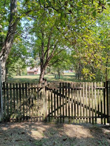 a wooden fence in a park with a tree at Domacinstvo Pecina Petnica in Petnica