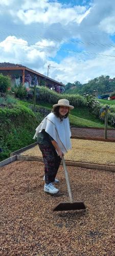 a woman in a hat holding a mop at Vista Farallones Hostel in Jardin