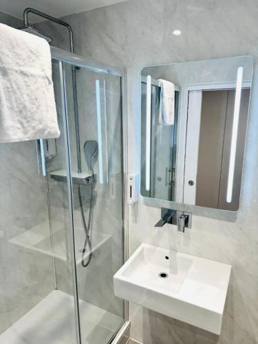 a bathroom with a sink and a shower and a mirror at Victoria Studios in London