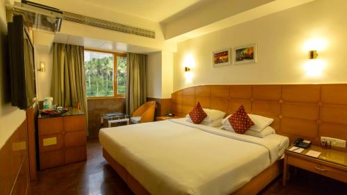 ein Hotelzimmer mit einem großen Bett in einem Zimmer in der Unterkunft Ramee Guestline Hotel Khar in Mumbai
