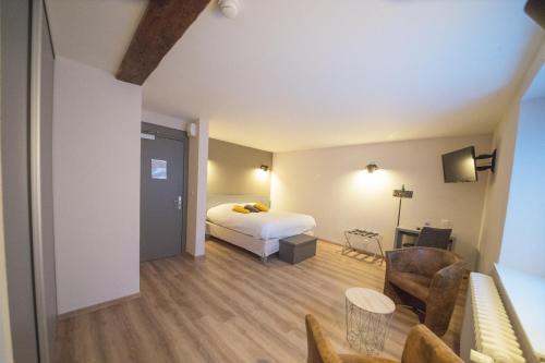 a hotel room with a bed and a living room at Logis Hôtel Restaurant Barrey in Orchamps-Vennes