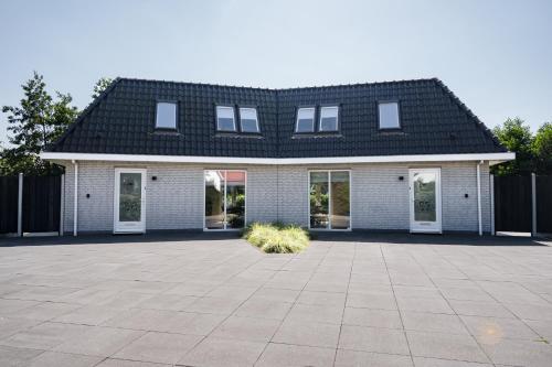 a white brick house with a black roof at Vakantiehuis Noordwijk in Noordwijk