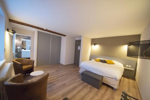 a hotel room with a bed and a table and chairs at Logis Hôtel Restaurant Barrey in Orchamps-Vennes