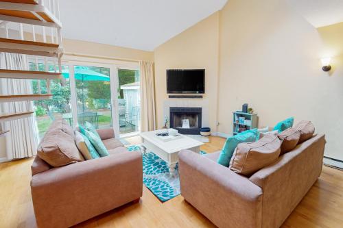 a living room with two couches and a fireplace at Ocean Edge Retreat in Brewster