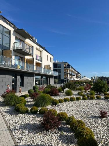 a garden in front of a building with plants at MB Apartments z Basenem i Ogrodem in Sarbinowo