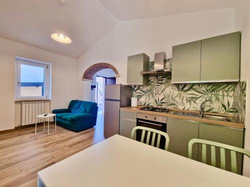 a kitchen with a table and a blue couch at Casa Adelina by TraMonti Apartments in Poggio Picenze