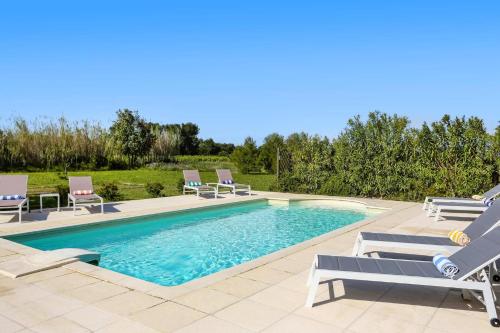 a swimming pool with chaise lounge chairs and a swimming pool at Villa Les Juliannes by Villa Plus in Azillanet