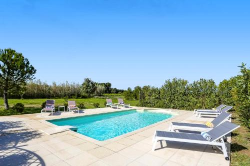 a swimming pool with chaise lounge chairs and a swimming pool at Villa Les Juliannes by Villa Plus in Azillanet