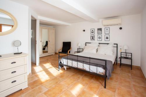a bedroom with a bed and a chair in it at Villa Les Juliannes by Villa Plus in Azillanet