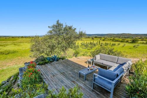 a patio with a couch and a table and flowers at Villa Les Juliannes by Villa Plus in Azillanet
