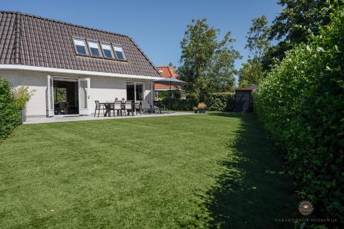 un patio de una casa con césped en Vakantiehuis Noordwijk, en Noordwijk