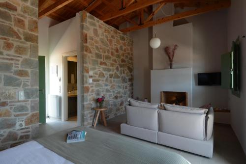 ein Wohnzimmer mit einem Sofa und einer Steinmauer in der Unterkunft Foresta in Medias Mores in Vlakhokeraséa