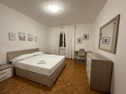 a bedroom with a bed and a desk and a mirror at Eleonora's House in Trieste