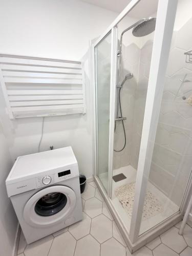 une machine à laver dans une salle de bain avec douche dans l'établissement 