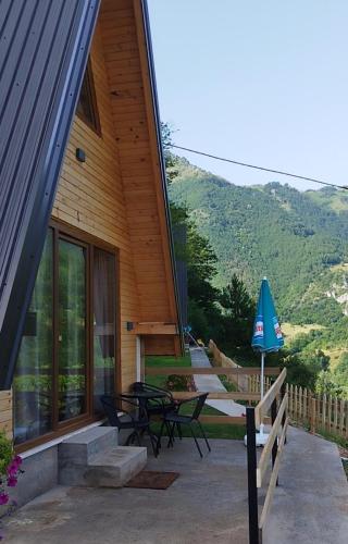 ein Haus mit einer Terrasse mit Tisch und Stühlen in der Unterkunft Vikendice Limski mir in Andrijevica