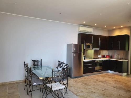 une cuisine avec une table, des chaises et un réfrigérateur dans l'établissement Très bel appartement en résidence avec parking, à Bastia
