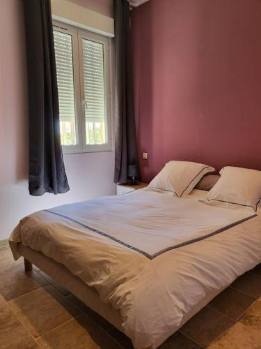 - un grand lit dans une chambre dotée d'un mur rouge dans l'établissement Très bel appartement en résidence avec parking, à Bastia