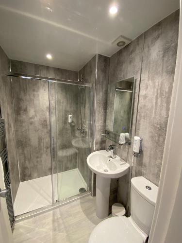 a bathroom with a shower and a toilet and a sink at Craigvrack Hotel & Restaurant in Pitlochry