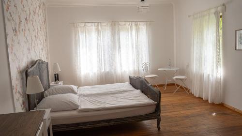 a bedroom with a bed and a table and a window at Hotel Rhodter Adler in Rhodt unter Rietburg