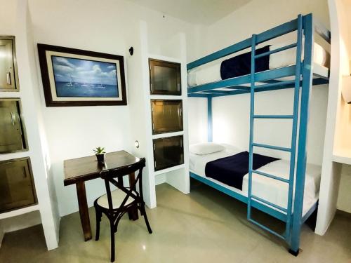 a room with a desk and a bunk bed at Hostal del Mar in Playa del Carmen