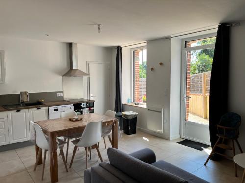 une cuisine et une salle à manger avec une table et des chaises dans l'établissement Gîte O Petit Bouchon à 10 min du Puy du Fou, à Sevremont