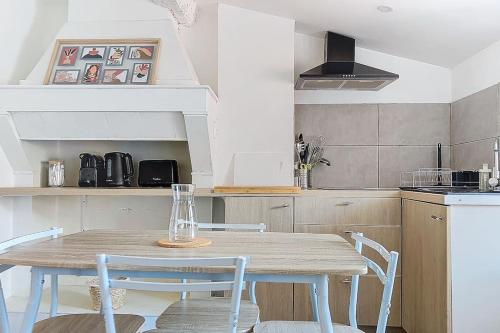 a kitchen with a wooden table and two chairs at Le Pradel in Carcassonne