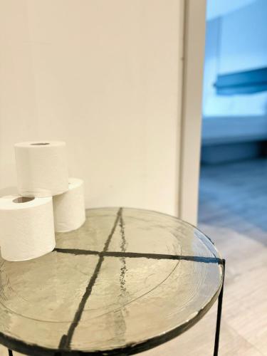 a glass table with two rolls of toilet paper on it at Victoria Studios in London