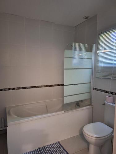a bathroom with a tub and a toilet and a sink at Maison tout confort Figeac in Figeac