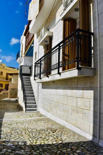 a building with stairs and a balcony on it at Porto Levante Anemos in Ermoupoli