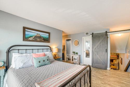 a bedroom with a bed and a sliding barn door at quarter Mi to Seawall Relaxing Galveston Condo! in Galveston