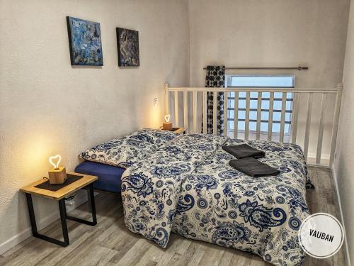 une chambre avec un lit avec une couette bleue et blanche dans l'établissement Douceur Nîmoise en centre ville - RDC et extérieur, à Nîmes